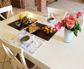Café, biscuits et tartines servis à table au sein d'une chambre d'hôtes