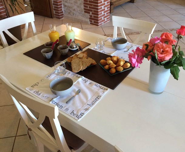 café, gâteaux, pain, jus de fruit et fleurs posés sur la table